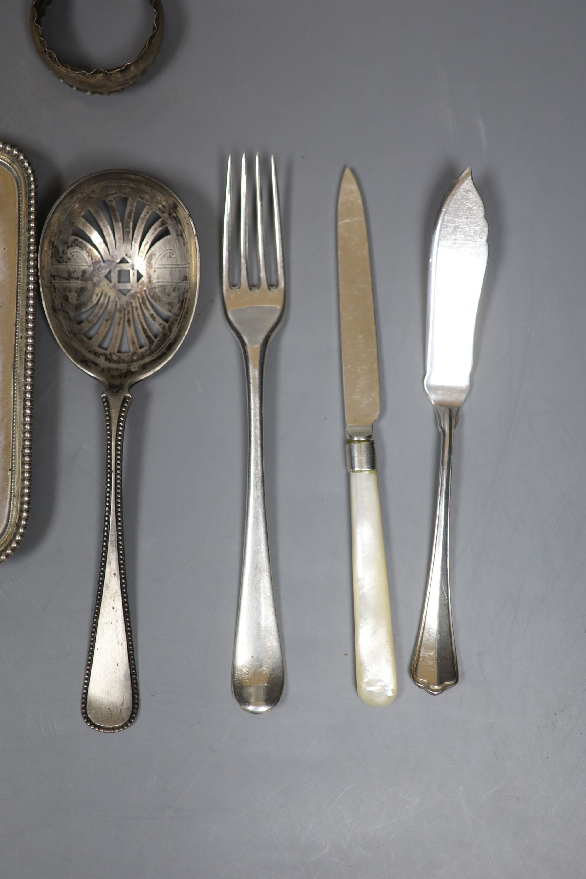 An 800 white metal stand, 16.4cm, twelve items of assorted silver flatware, a silver napkin ring, frame and box.